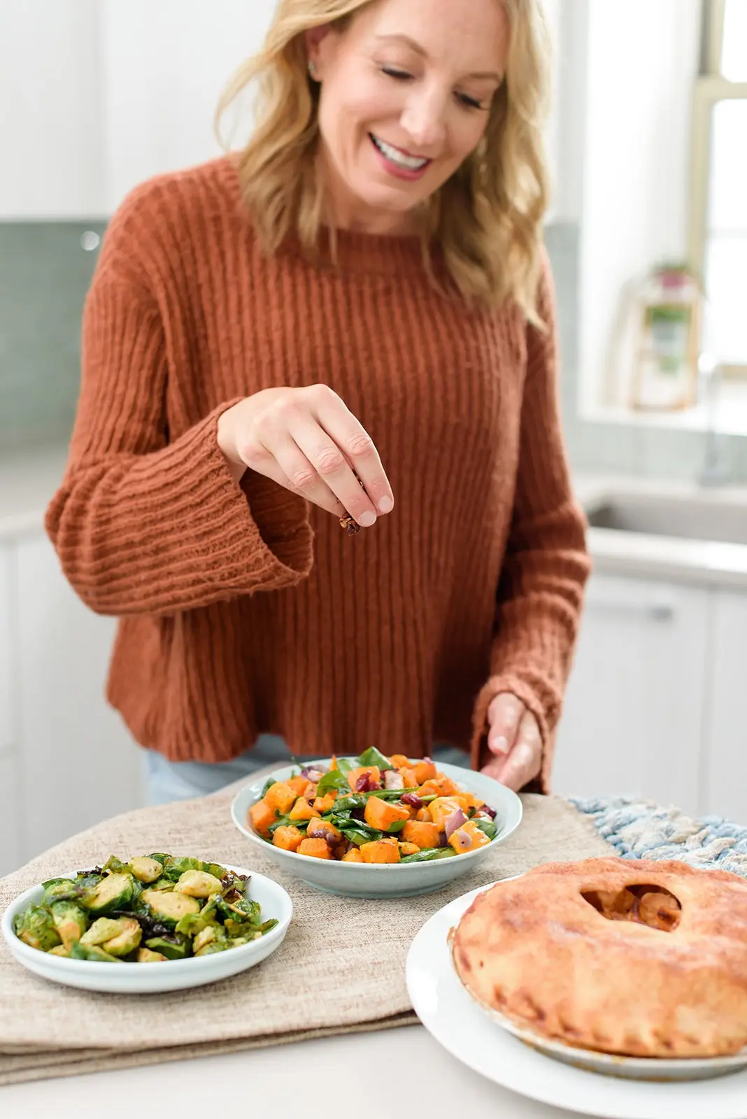 Julie Hartigan finishing a fall dish in her kitchen