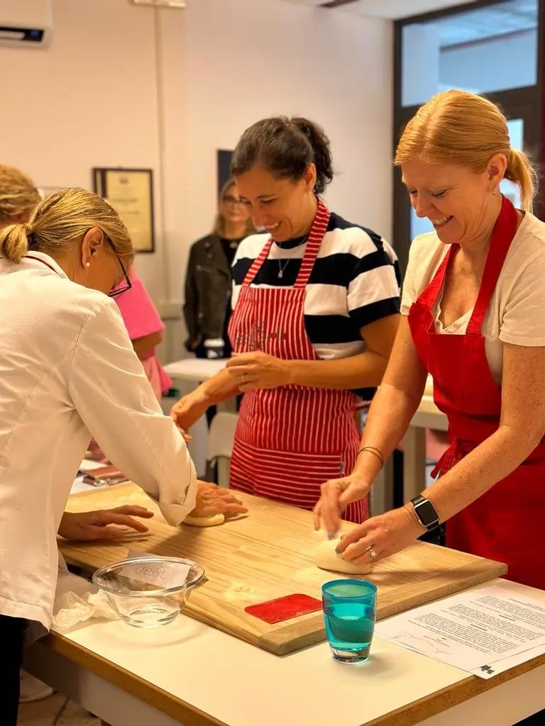 Women smiling while doing a cooking class