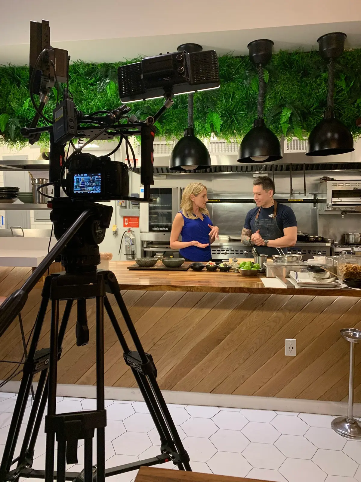 A camera filming Julie Hartigan in a studio kitchen