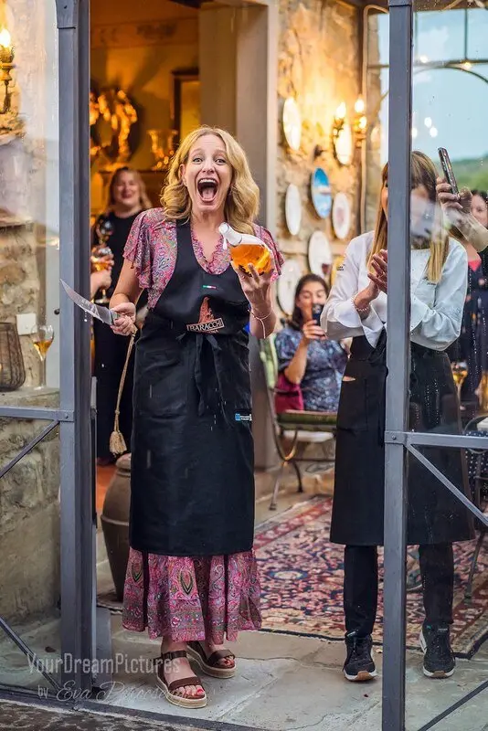Julie Hartigan sabering champagne at a restaurant event