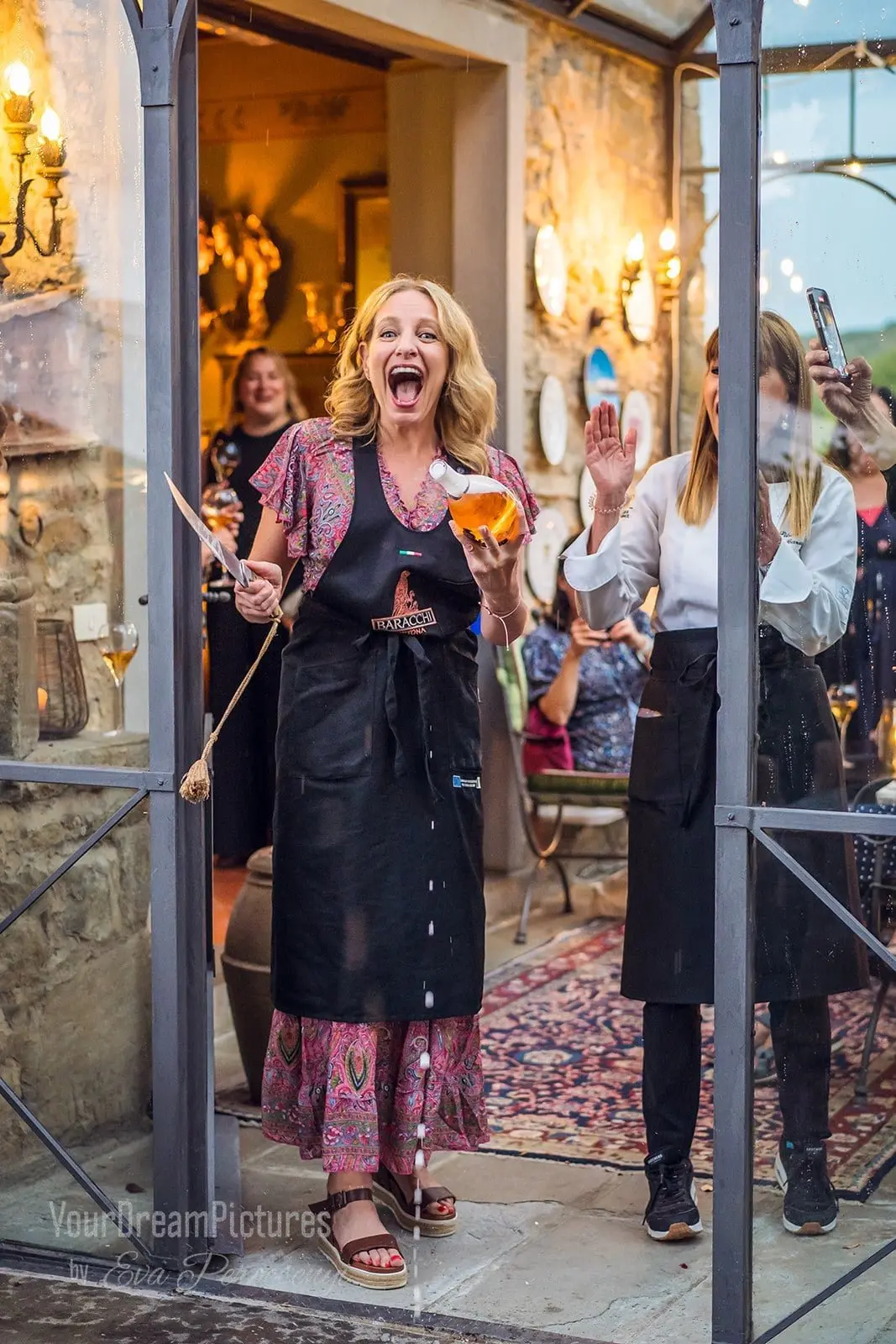 Julie Hartigan sabering a bottle of champagne