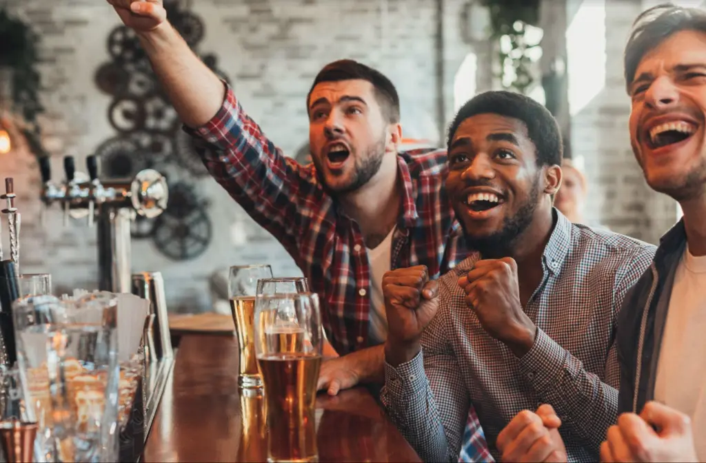 Friends cheering while watching a football game